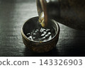 Pour hot sake into the glass. 143326903
