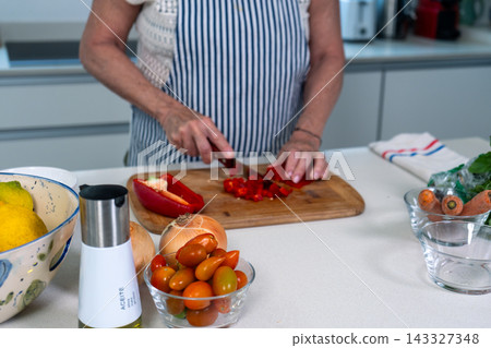 Woman dicing red peppers with precision at a bright kitchen counter 143327348