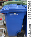 A large blue trash can in a foreign country on the side of the road 143327566