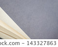 Open book showing blank pages with textured gray paper providing copy space, abstract background 143327863