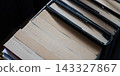 Stacked book pages with spines creating a pattern, representing education, reading, and knowledge acquisition 143327867