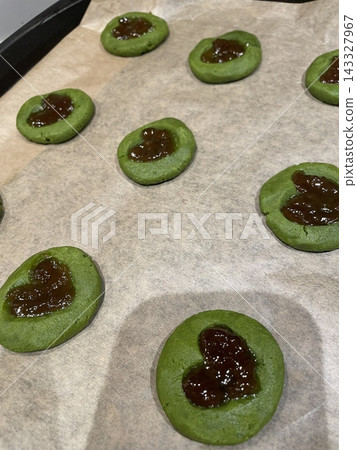 Thumbprint cookies with soft buttery dough shaped into small rounds, each pressed in the center and filled with sweet jam, creating a colorful and classic homemade treat Thumbprint cookies with soft buttery dough shaped into small rounds, each pressed in the center and filled with sweet jam, creating a colorful and classic homemade treat 143327967