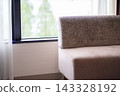 A living room with a couch by the window. A bright room with a view of the garden. 143328192