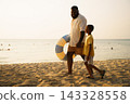 African American father and child walking on beach with swim ring 143328558