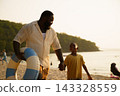 African American father and child walking on beach with swim ring 143328559