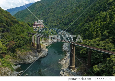 一張空拍照片,拍攝的是德島縣三好市一座橫跨峽谷的鐵路橋。 一張空拍照片,拍攝的是德島縣三好市一座橫跨峽谷的鐵路橋。 143330020