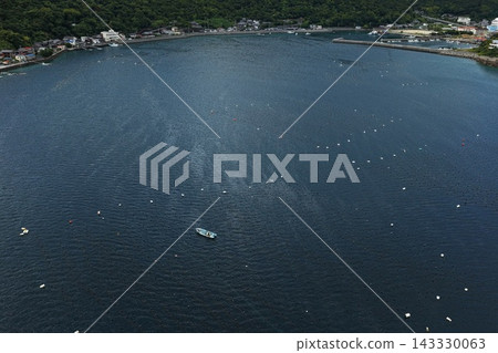 空拍照片捕捉了愛媛縣愛南町的水產養殖筏和漁港。 空拍照片捕捉了愛媛縣愛南町的水產養殖筏和漁港。 143330063