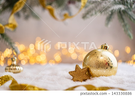 Gold Christmas Ornaments with Star and Ribbon on Snow 143330886