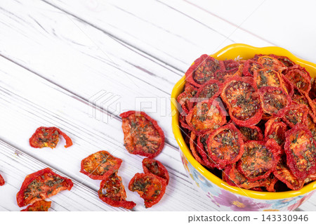 Bowl with dehydrated red fragrant tomatoes with herbs and spices. 143330946