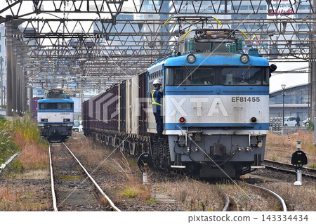 一輛電力機車和一列貨運列車正在鐵軌上行駛。 一輛電力機車和一列貨運列車正在鐵軌上行駛。 143334434