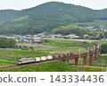 一輛電力機車和一列貨運列車正在鐵軌上行駛。 143334436