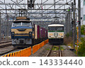 一輛電力機車和一列貨運列車正在鐵軌上行駛。 143334440