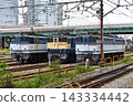 一輛電力機車和一列貨運列車正在鐵軌上行駛。 143334442