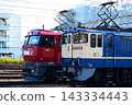 一輛電力機車和一列貨運列車正在鐵軌上行駛。 143334443