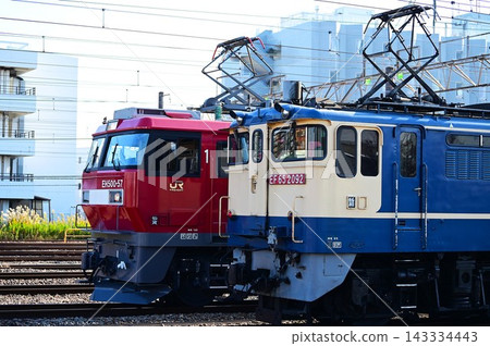 一輛電力機車和一列貨運列車正在鐵軌上行駛。 一輛電力機車和一列貨運列車正在鐵軌上行駛。 143334443