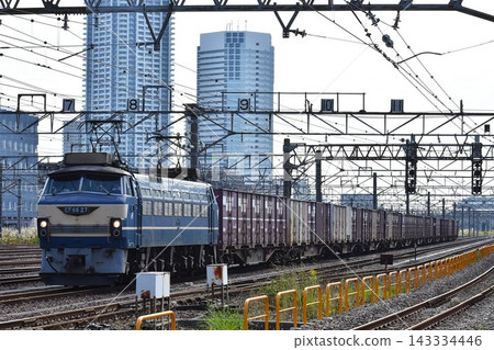 一輛電力機車和一列貨運列車正在鐵軌上行駛。 143334446