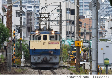 一輛電力機車和一列貨運列車正在鐵軌上行駛。 143334447