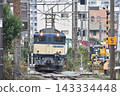 一輛電力機車和一列貨運列車正在鐵軌上行駛。 143334448