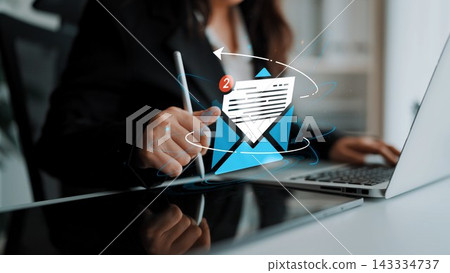 Businesswoman Engaging with Email Notifications on Laptop in Modern Office Environment with Digital Graphics Overlaying the Screen. Entropy Businesswoman Engaging with Email Notifications on Laptop in Modern Office Environment with Digital Graphics Overlaying the Screen. Entropy 143334737