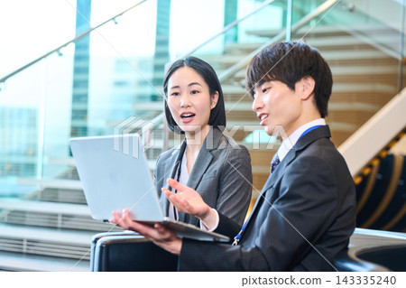 商務人士在開會時一邊看著筆記型電腦一邊微笑。 商務人士在開會時一邊看著筆記型電腦一邊微笑。 143335240