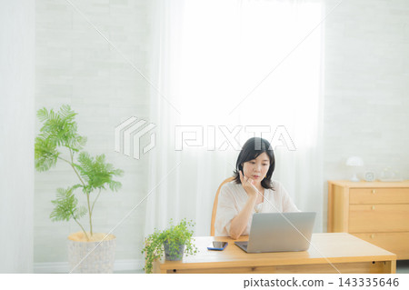 一個女人在客廳裡看電腦 一個女人在客廳裡看電腦 143335646