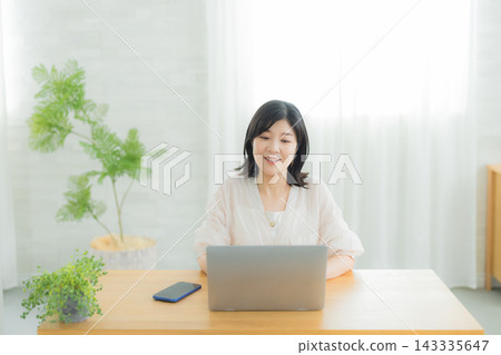 一個女人在客廳裡看電腦 一個女人在客廳裡看電腦 143335647