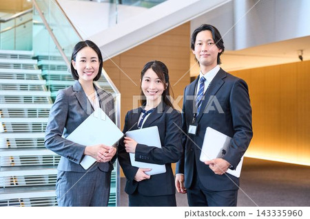 辦公室裡有三位帶著筆記型電腦的商務人士。 辦公室裡有三位帶著筆記型電腦的商務人士。 143335960