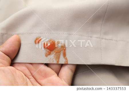 Sauce spilled on beige pants or shirt. Concept of dirty clothes Sauce spilled on beige pants or shirt. Concept of dirty clothes 143337553