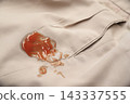 red tomato ketchup stain on khaki fabric. Laundry stain removal concept. 143337555