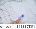 hand washing a white shirt with blue ink stain on pocket in soapy water. Ink stain removal and laundry care concept. 143337564