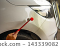 Removing dents on the car. PDR technology. Car body repair without painting. 143339082