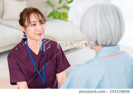 醫院病房裡，女護士和護理人員正在和一位年長的女病人交談（醫學圖片） 143339698