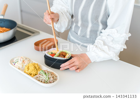 一位女士的手在廚房裡打包午餐盒(相妻便當) 一位女士的手在廚房裡打包午餐盒(相妻便當) 143341133