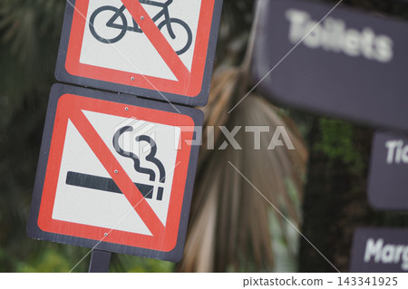 In this public area, there are signs indicating no smoking and no bicycles allowed In this public area, there are signs indicating no smoking and no bicycles allowed 143341925