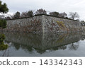 姬路城的石牆漂浮在護城河上，籠罩在初冬陰雲密佈的天空下。 143342343