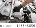 • Automotive mechanics checking the engine oil level and condition using a dipstick. 143343656