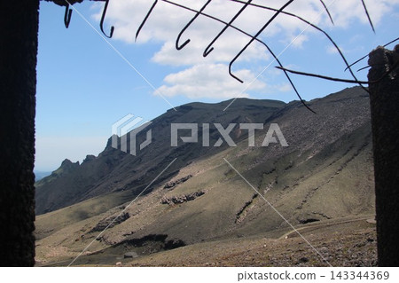 The spectacular view of the sharp rocky peaks of Washigamine and Toragamine on the northern face of Mount Takadake, as seen from the East Crater Observation Deck of Mount Aso in Kumamoto Prefecture and the area around Sensuikyo Gorge. 143344369