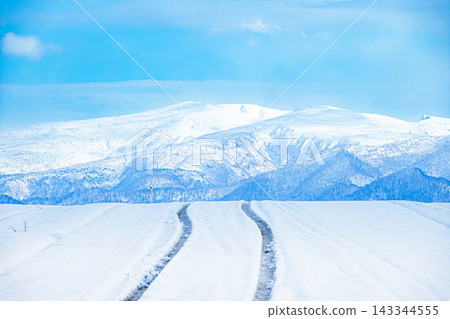 冬季北海道美瑛市,道路被積雪覆蓋,結冰,到處都是汽車輪胎印。 冬季北海道美瑛市,道路被積雪覆蓋,結冰,到處都是汽車輪胎印。 143344555