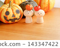 Peg dolls wearing mini pumpkin hats and Halloween pumpkins 143347422