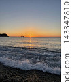 海岸線波濤洶湧,夕陽西下,沉入地平線。 海岸線波濤洶湧,夕陽西下,沉入地平線。 143347810