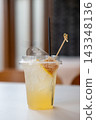 Iced honey lemon soda topped with a fresh honeycomb piece on a cafe table. 143348136