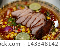 Spicy fried pork neck salad with fresh herbs and chili served on a plate. 143348142