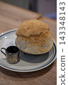 Japanese style milky shaved ice topped with chewy mochi pieces and dusted with kinako roasted soybean flour. 143348143