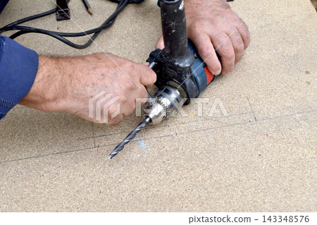 Installing a drill bit into an electric drill. Installing a drill bit into an electric drill. 143348576