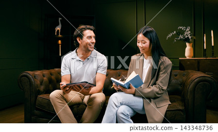 Content creators discussing podcast production on a sofa 143348736