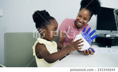 Young girl playing with glove balloon at hospital Young girl playing with glove balloon at hospital 143348844