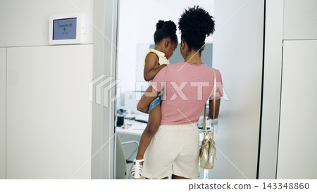 Mother and daughter entering medical appointment room Mother and daughter entering medical appointment room 143348860