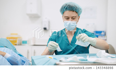 Healthcare worker preparing sterile instruments for medical procedure Healthcare worker preparing sterile instruments for medical procedure 143348898