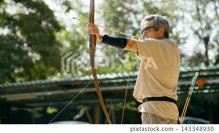 Senior man aiming traditional bow, hitting life goals 143348930