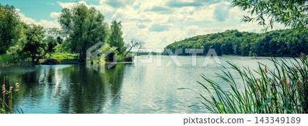 View of a lake with a beautiful reflection on the water. Rural summer landscape View of a lake with a beautiful reflection on the water. Rural summer landscape 143349189